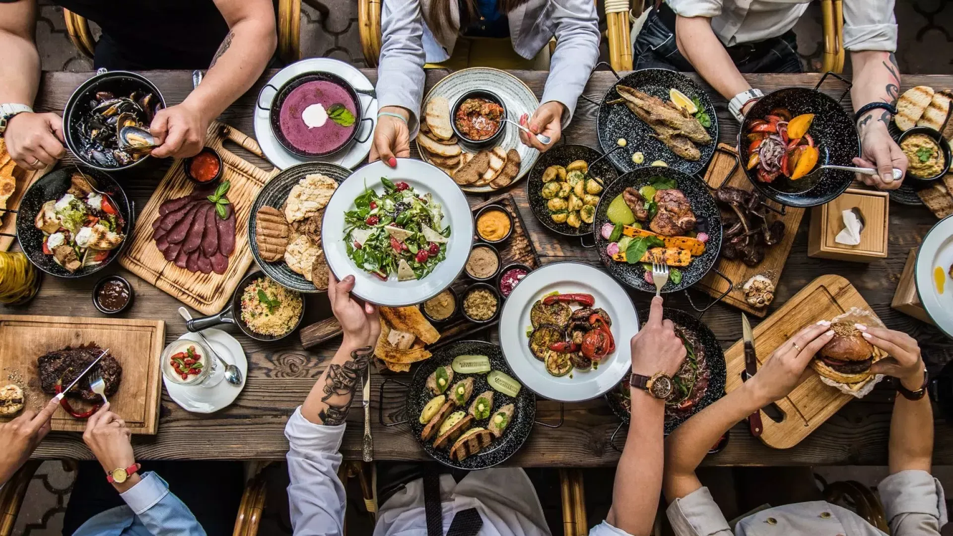 Des gens assis à une table à manger, partageant de la nourriture.