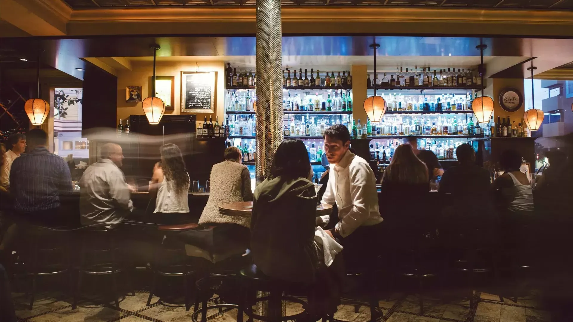 Un couple partage des boissons dans un bar animé de San Francisco.